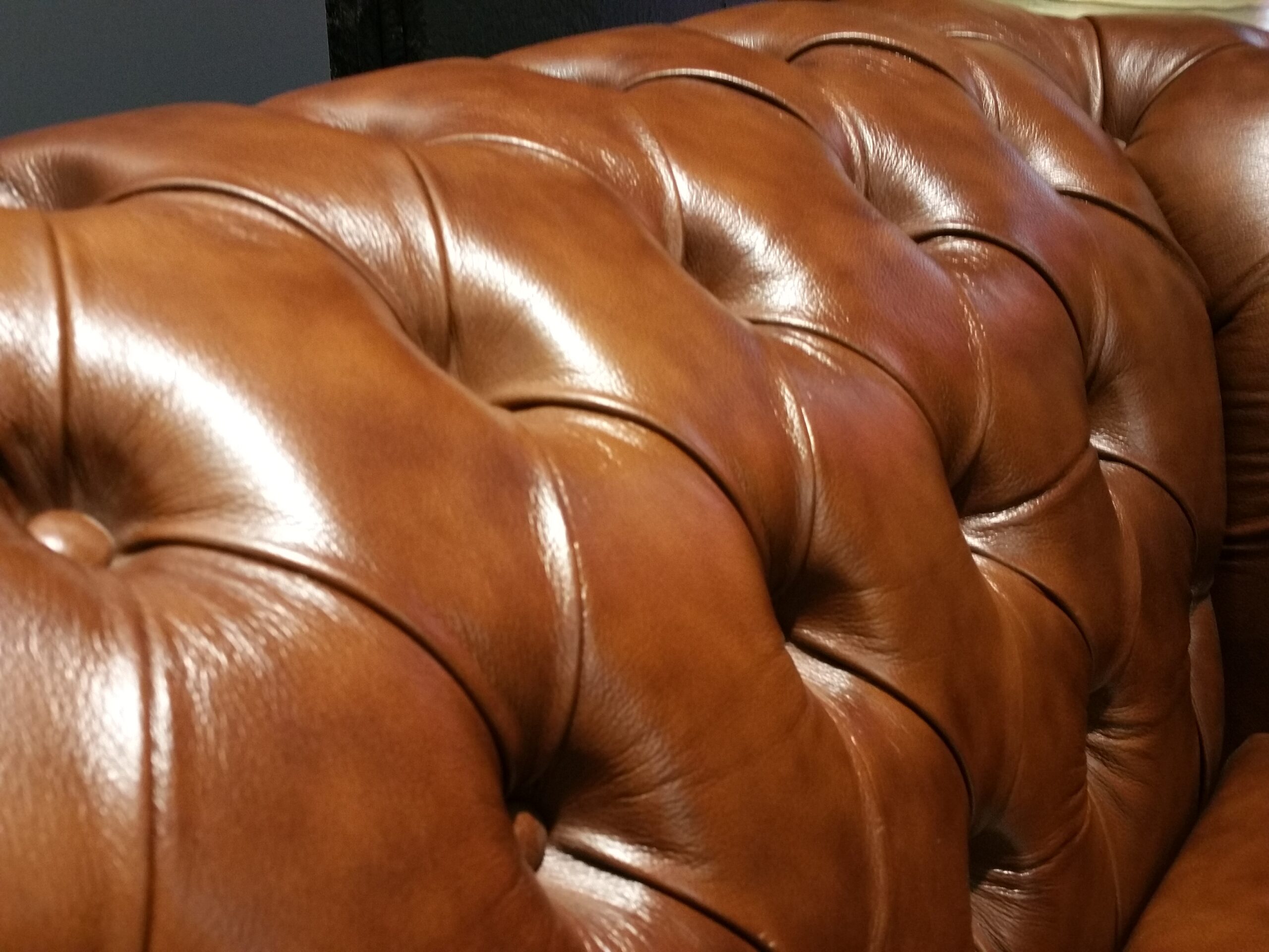 Nahaufnahme eines Ledersofas mit Knöpfen, handgefertigt von unserer Polsterei