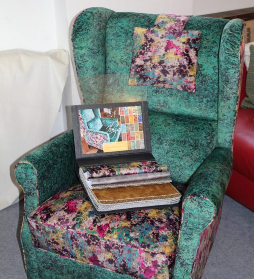 Ein grüner Stuhl mit einem Buch auf dem Sitz in unserer Polsterei.